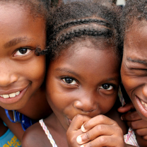 Little black girl with braids with two other black kids